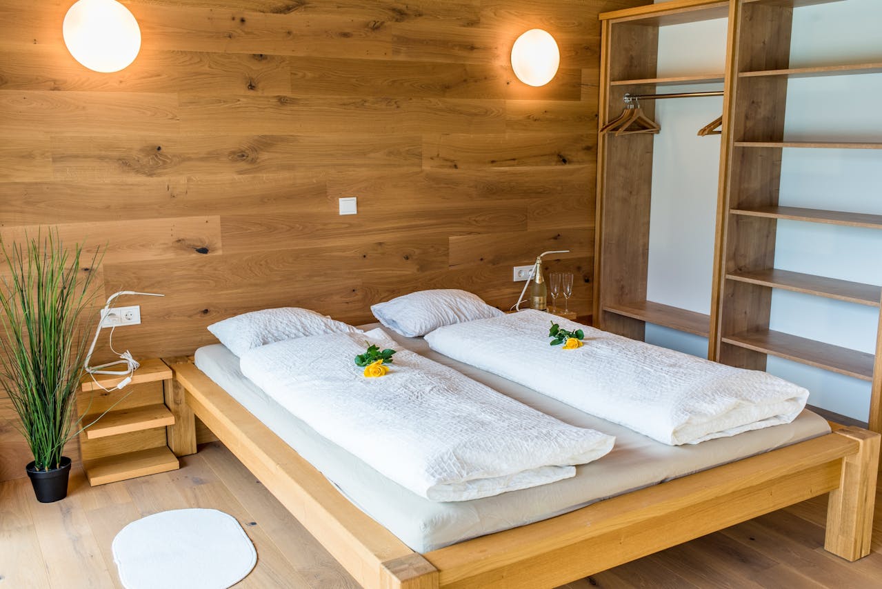 اتاق خواب مدرن با سرویس خواب چوبی روشن و تخت دونفره با دیوار چوبی و دکور مینیمال